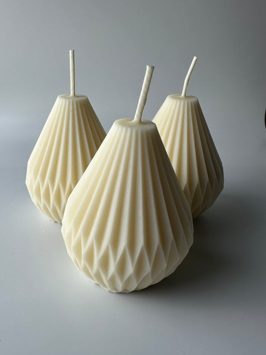 Dimensional candles are a type of pillar candle.  A trio of natural unscented pear shaped geometric pillar candles is shown.